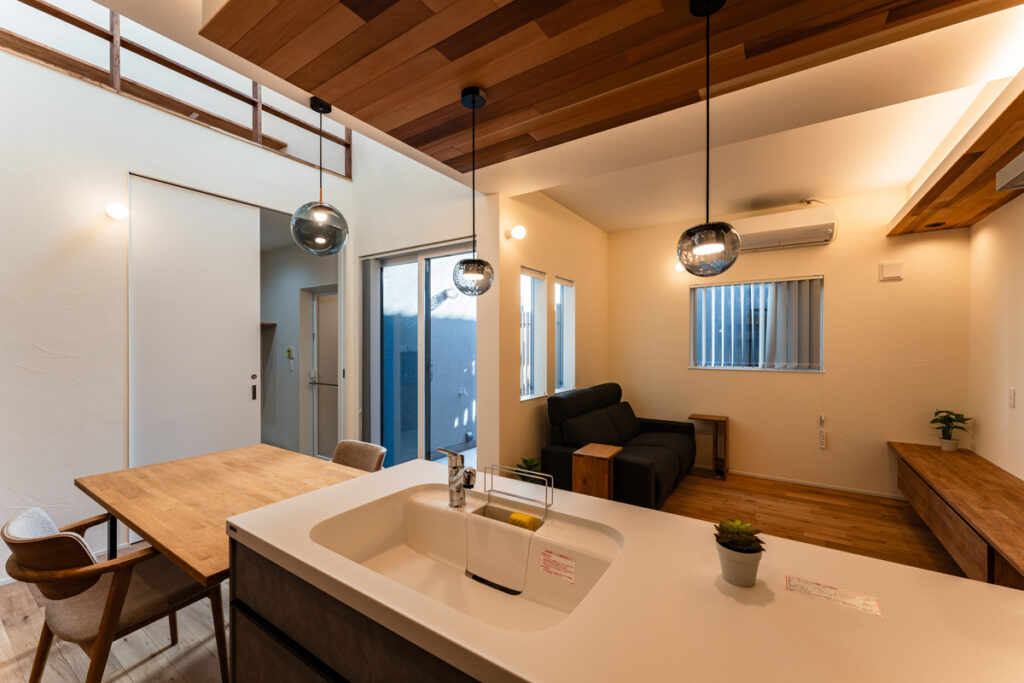 レッドシダーの羽目板天井と吹き抜けがある、キッチンから見渡した開放的なLDK