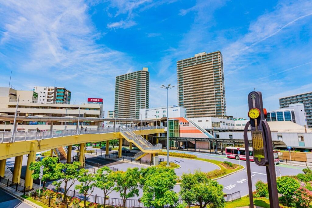 青空の下に広がるJR茨木駅前のロータリー。ペデストリアンデッキと高層マンションが立ち並ぶ都市景観。