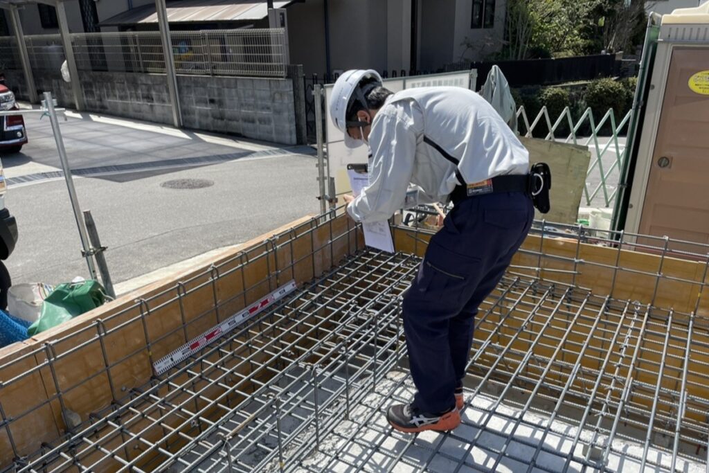 ⑩住宅建築現場で基礎配筋または構造金物の検査が行われている様子