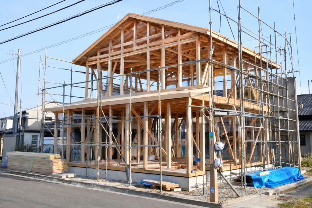 上棟を終え、木造軸組工法の丈夫な柱や梁が組み上がった建築中の住宅構造。