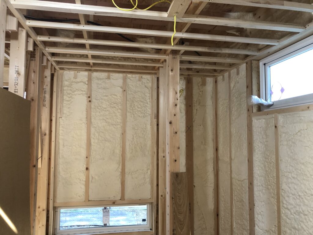 建築中の住宅の壁面に、気密性と断熱性を高める発泡ウレタンフォームが隙間なく施工された様子。