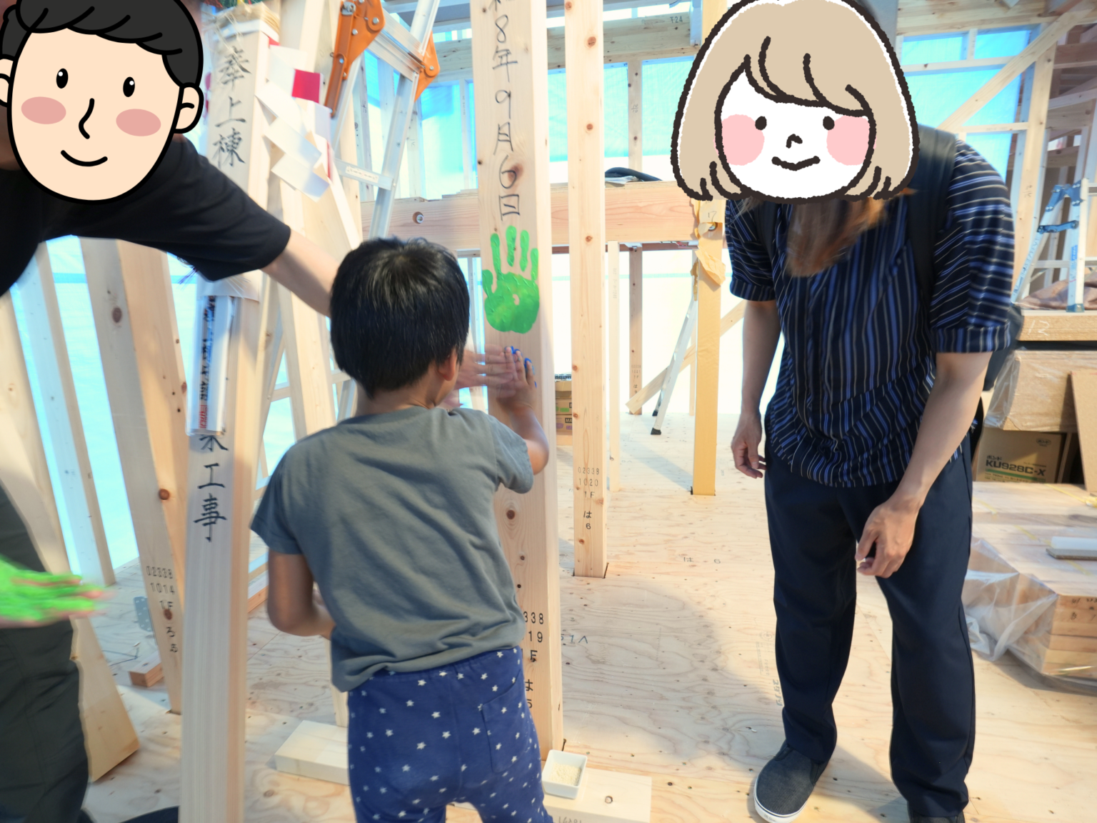 上棟式を終えた木造住宅の建築現場で、記念として柱に手形を押す子どもと、それを見守る家族の様子。