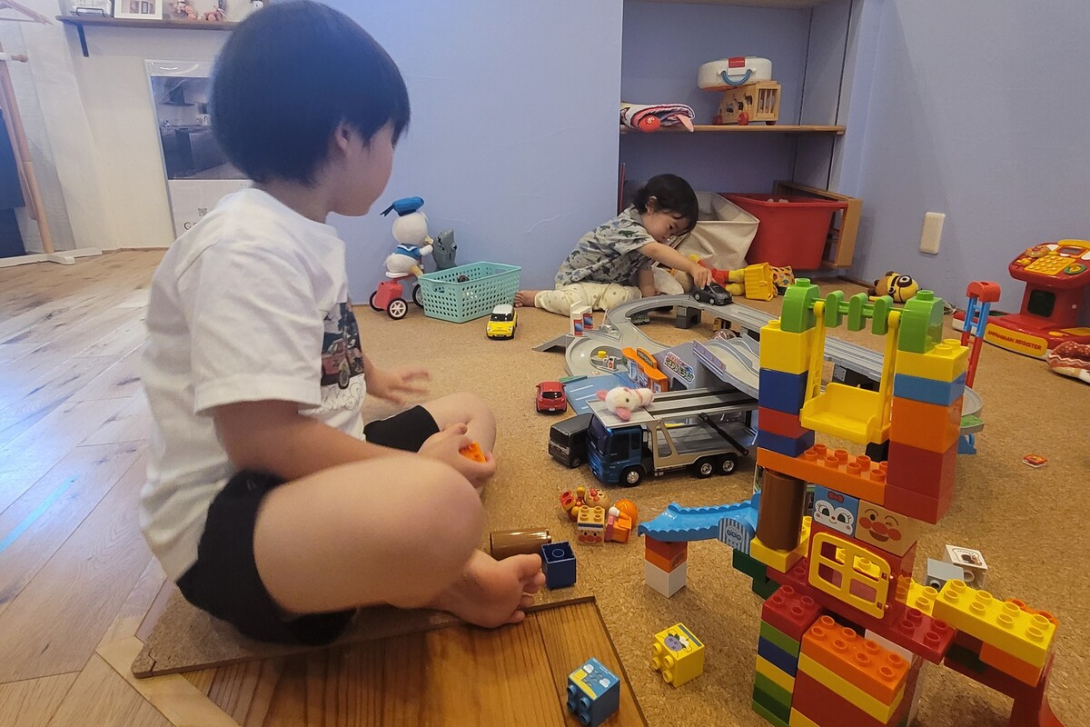 キッズスペースで、おもちゃのブロックを使って楽しそうに遊ぶ兄弟。