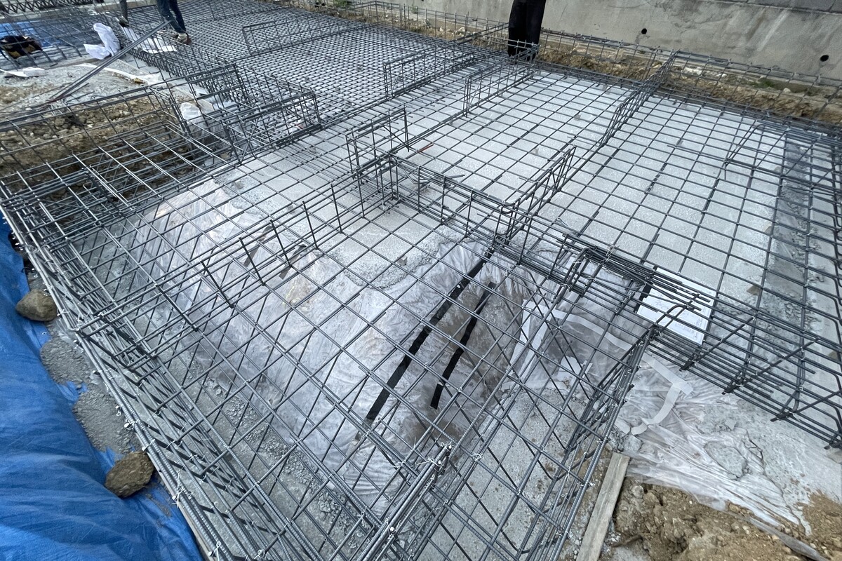 住宅のベタ基礎工事現場。防湿シートの上に鉄筋が等間隔にしっかりと組まれた、コンクリート打設前の配筋工程です。