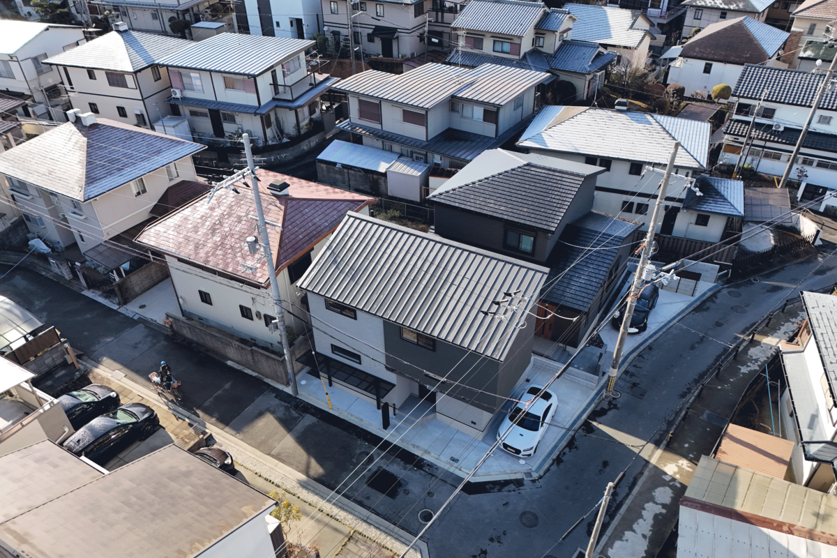 住宅街を上空から見下ろした俯瞰風景。隣接する家々との距離感や、採光を考慮した多様な屋根の形状が確認できます。