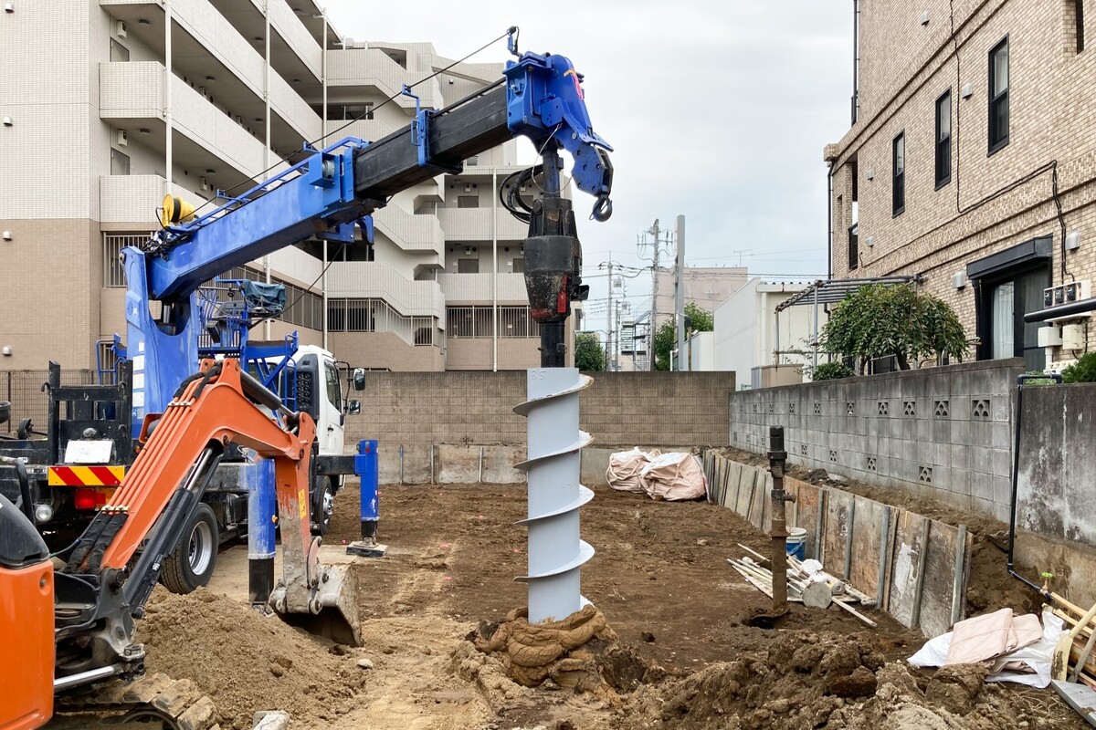 住宅街の建築予定地で、専用の重機を使って地面に太いドリルを打ち込み、住宅建築前の地盤調査や改良工事を行っている現場。
土地探し.jpg