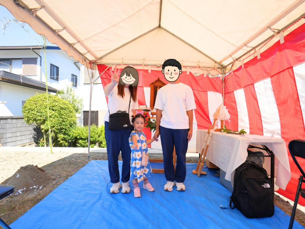 紅白幕が張られた地鎮祭のテント内で、祭壇を背に記念撮影をするご家族の様子。新しい家づくりの始まりを祝う風景です。